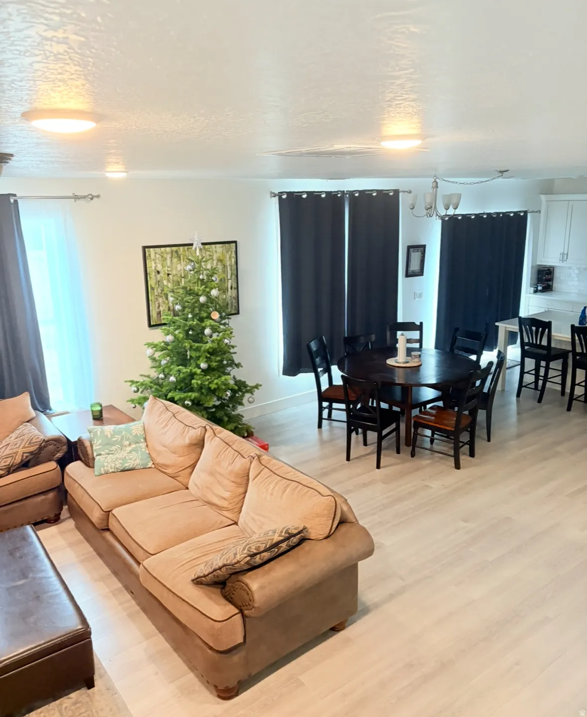Living room featuring a textured ceiling, light wood-type flooring, and a chandelier