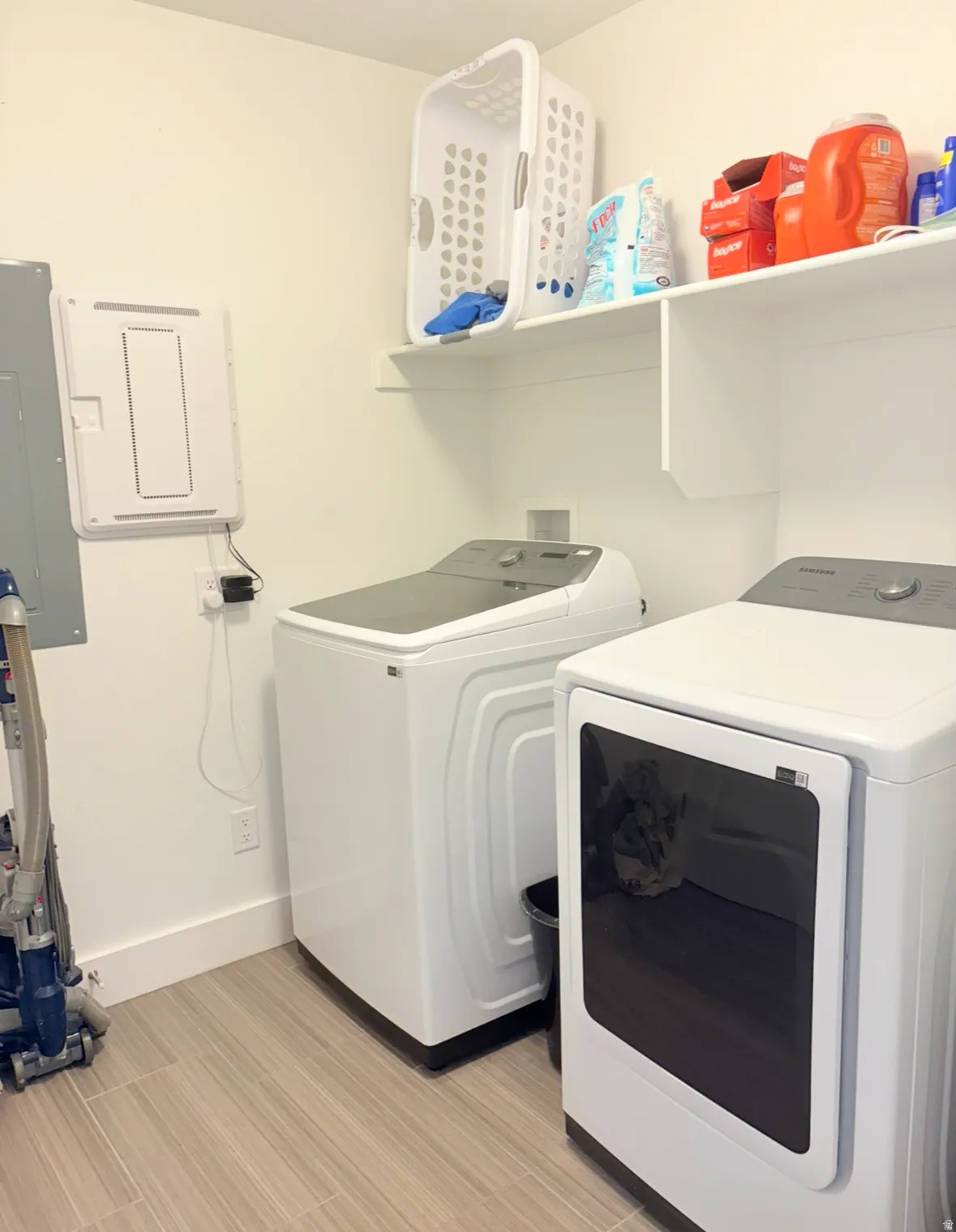 Laundry room featuring electric panel, separate washer and dryer, and light wood finished floors