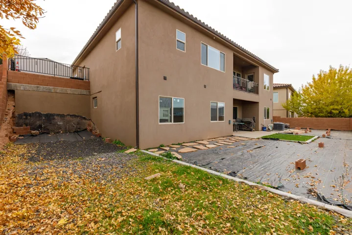 Back of house with a patio area, a balcony, stucco siding, and a tile roof