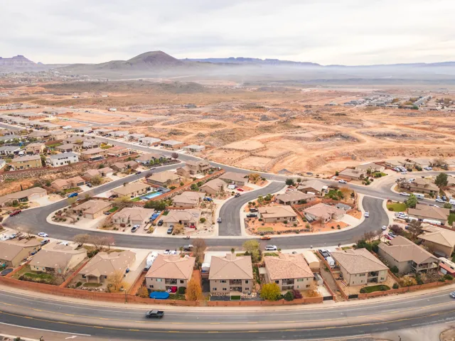 Aerial view of property's location with a mountainous background and nearby suburban area