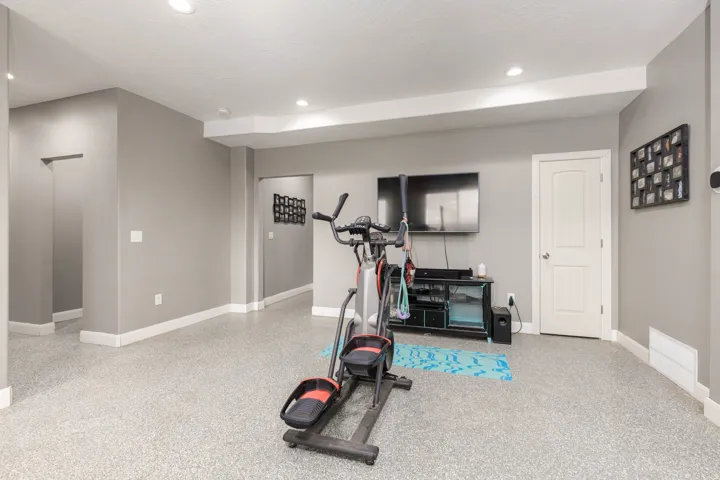 Exercise room with baseboards and recessed lighting