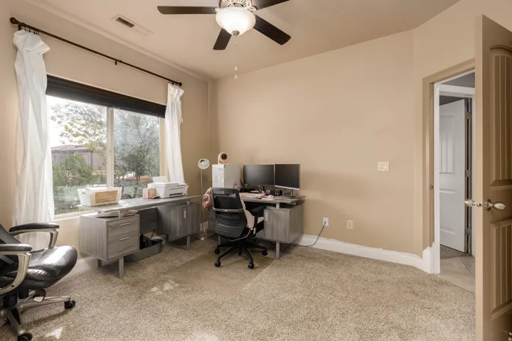 Office area featuring light carpet and ceiling fan