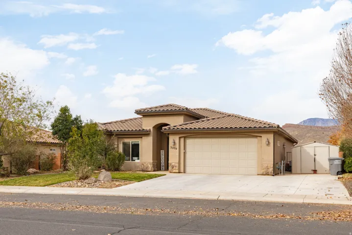 Mediterranean / spanish house featuring concrete driveway, stucco siding, an attached garage, stone siding, and a tile roof