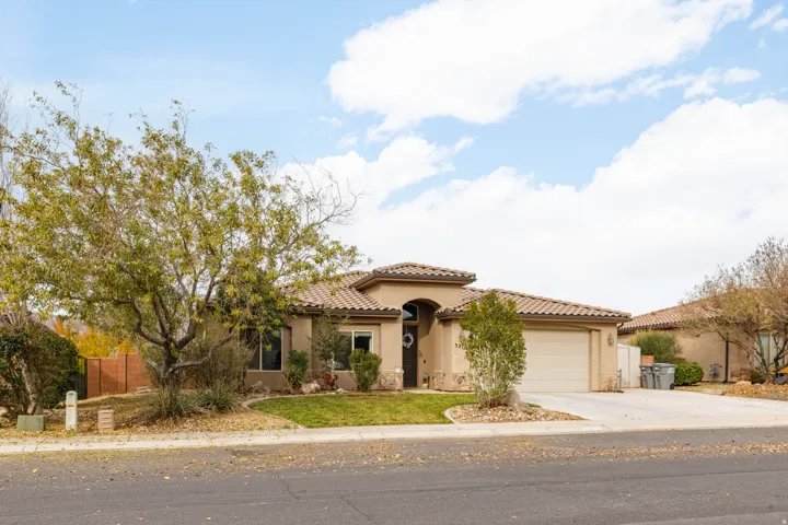 Mediterranean / spanish-style house featuring stucco siding, a tiled roof, concrete driveway, and a garage