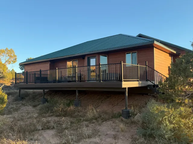 Back of property featuring a metal roof and a deck
