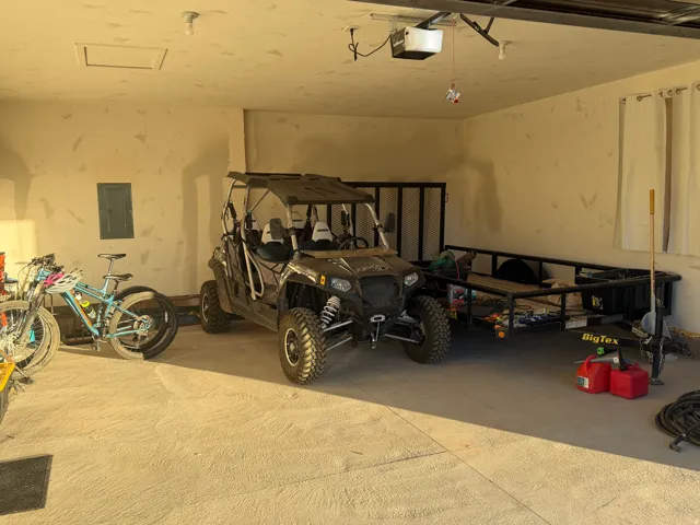 Garage featuring electric panel and a garage door opener