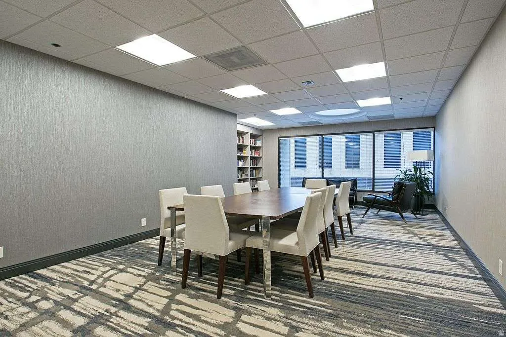 Dining area with a paneled ceiling and wallpapered walls