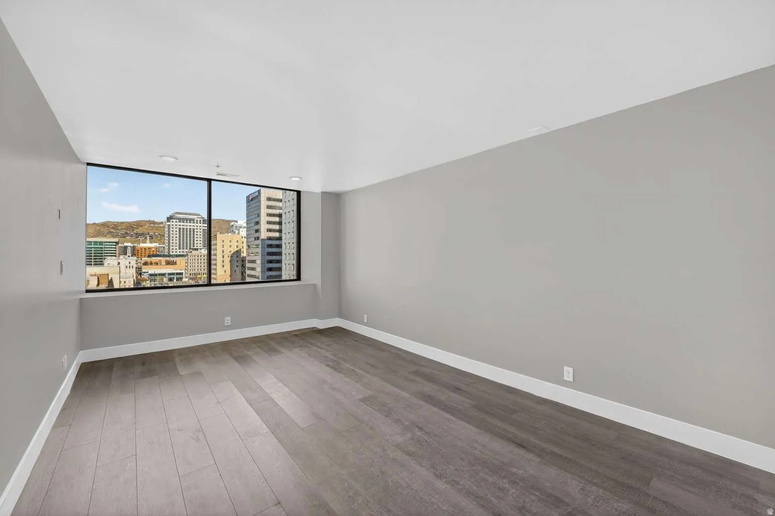 Spare room with dark wood finished floors and a city view