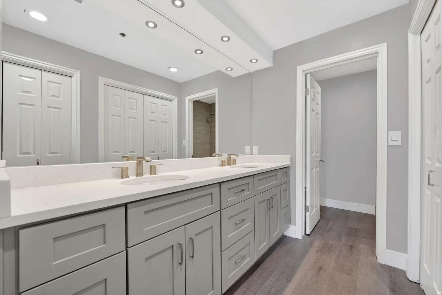 Full bath featuring a closet, double vanity, dark wood-style floors, and recessed lighting