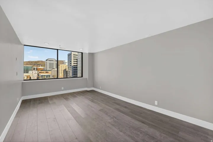 Spare room with dark wood finished floors and a city view