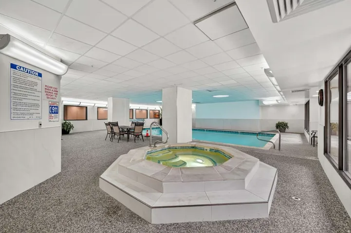 Community pool featuring an in-ground hot tub