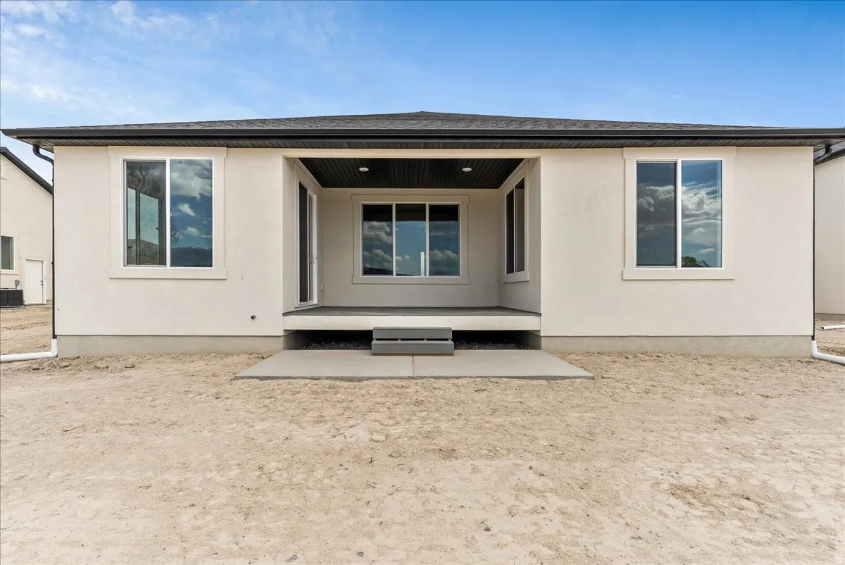 Rear view of house featuring a patio and stucco siding