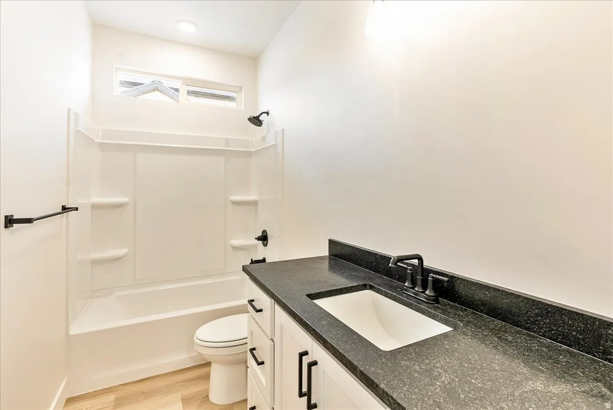 Bathroom with vanity, light wood-style flooring, and bathing tub / shower combination