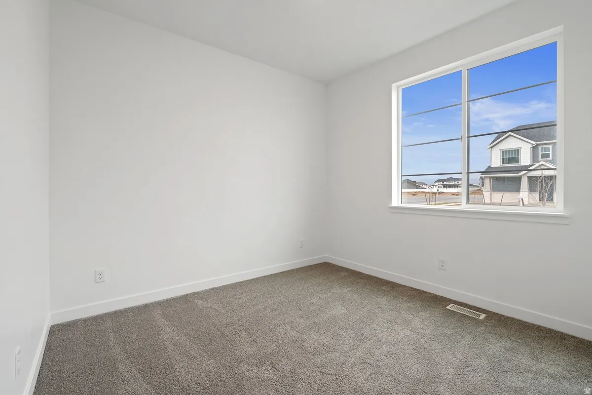 Spare room with carpet and baseboards