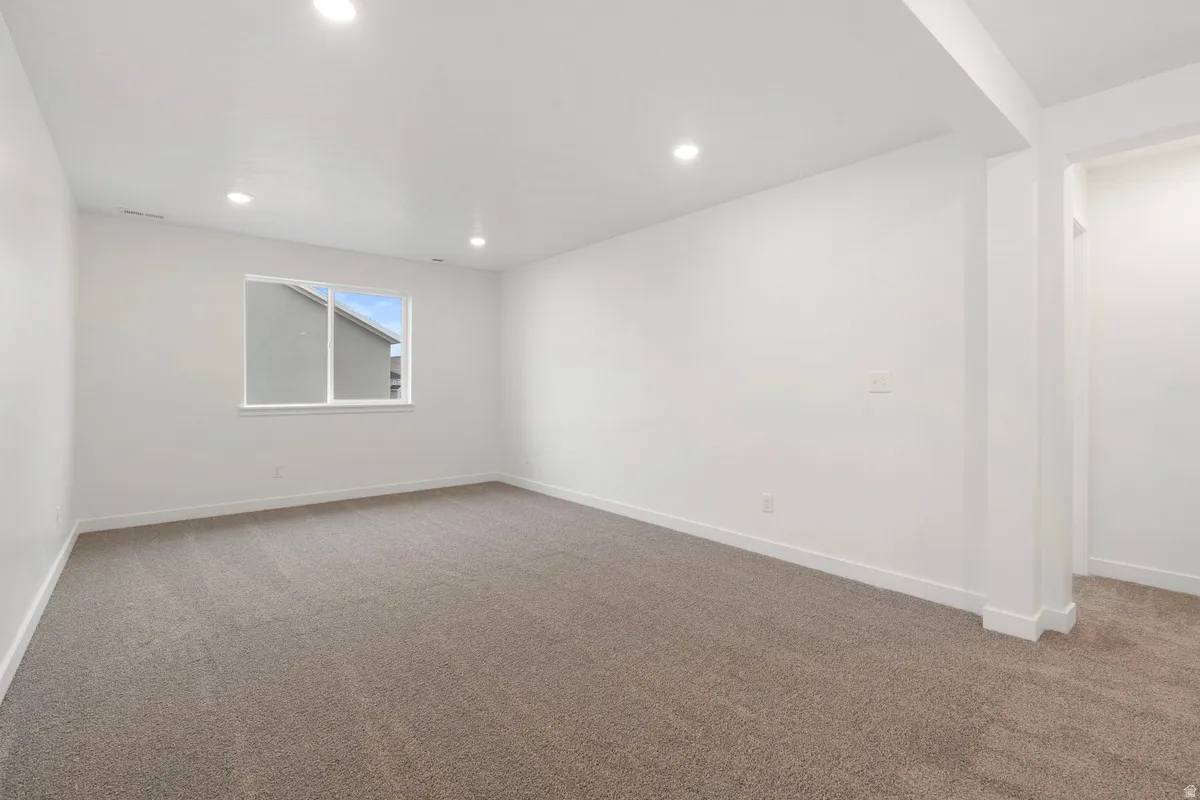 Unfurnished room with light colored carpet and recessed lighting
