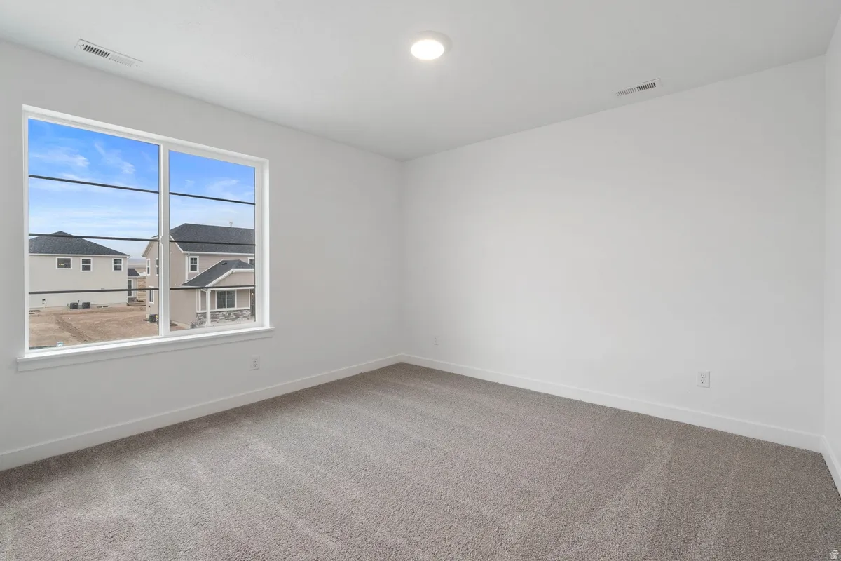 Empty room featuring carpet and baseboards