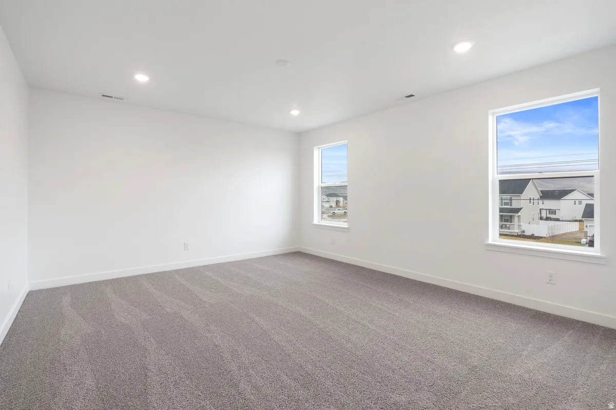 Carpeted empty room featuring recessed lighting