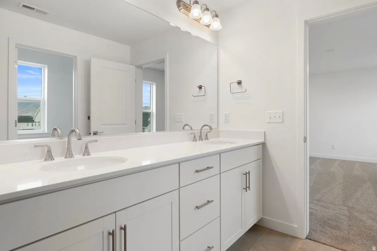 Full bathroom with double vanity and light carpet
