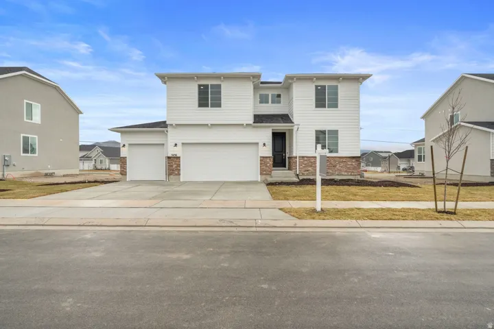 View of front of property featuring concrete driveway and an attached garage