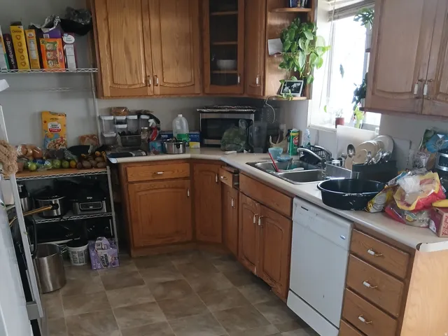 Kitchen with light countertops, wood finish cabinets, stainless steel appliances, glass fronted cabinets, and open shelves