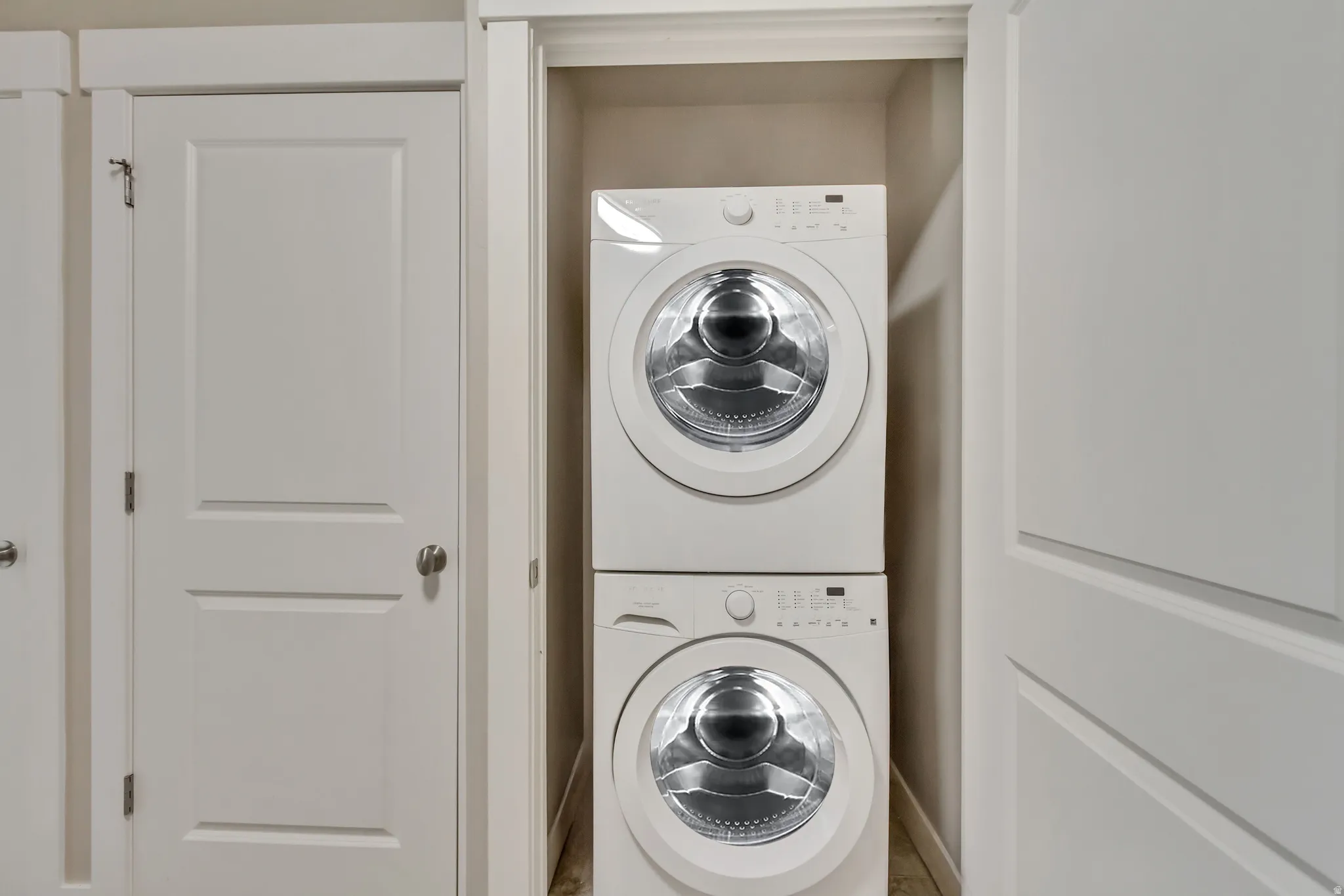 Washroom with stacked washer and clothes dryer in the main