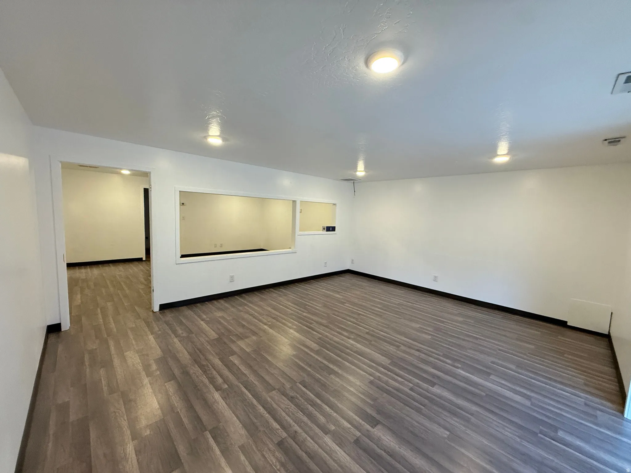 Unfurnished room featuring dark wood-type flooring and baseboards