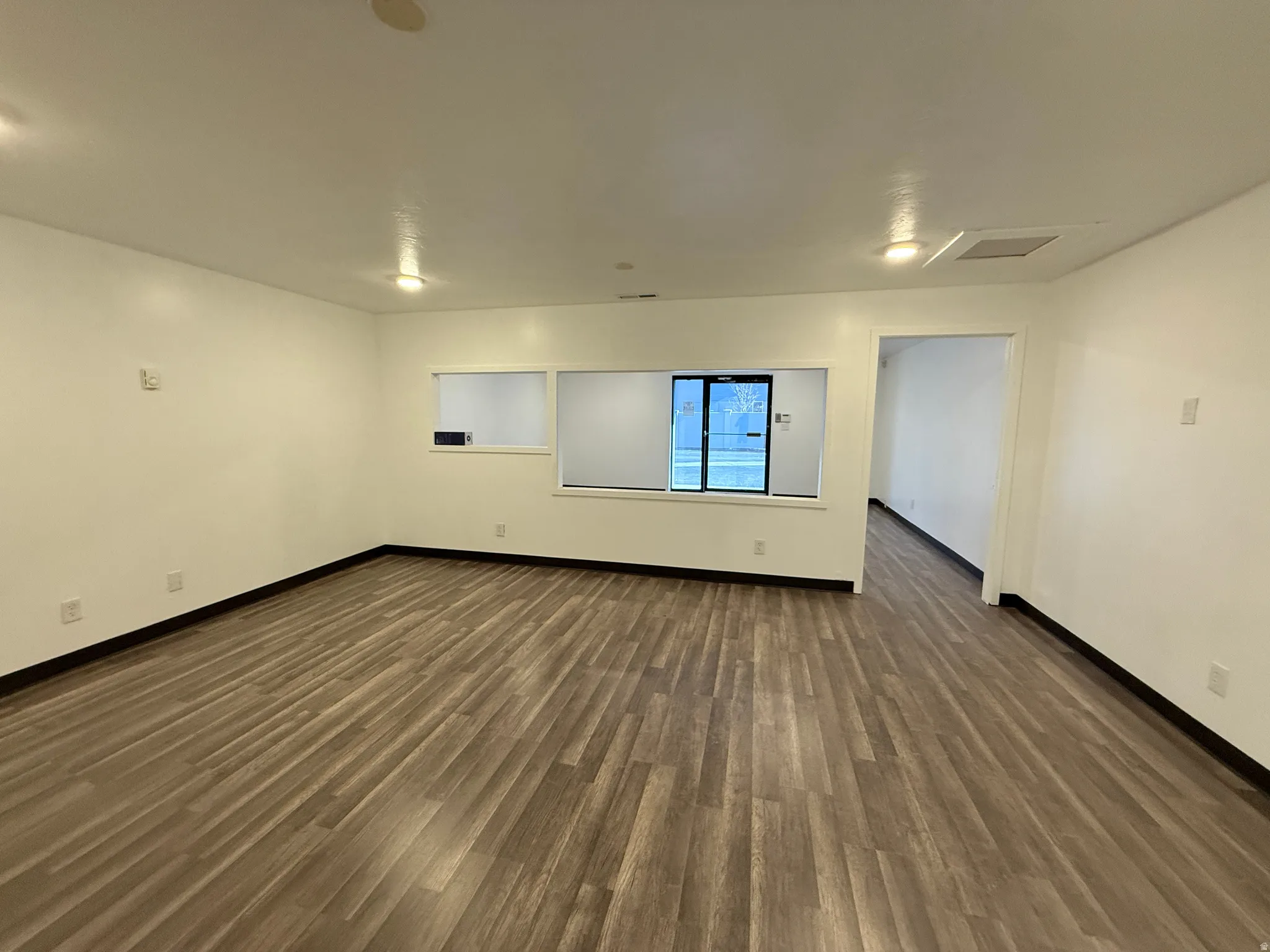 Spare room with baseboards and dark wood finished floors