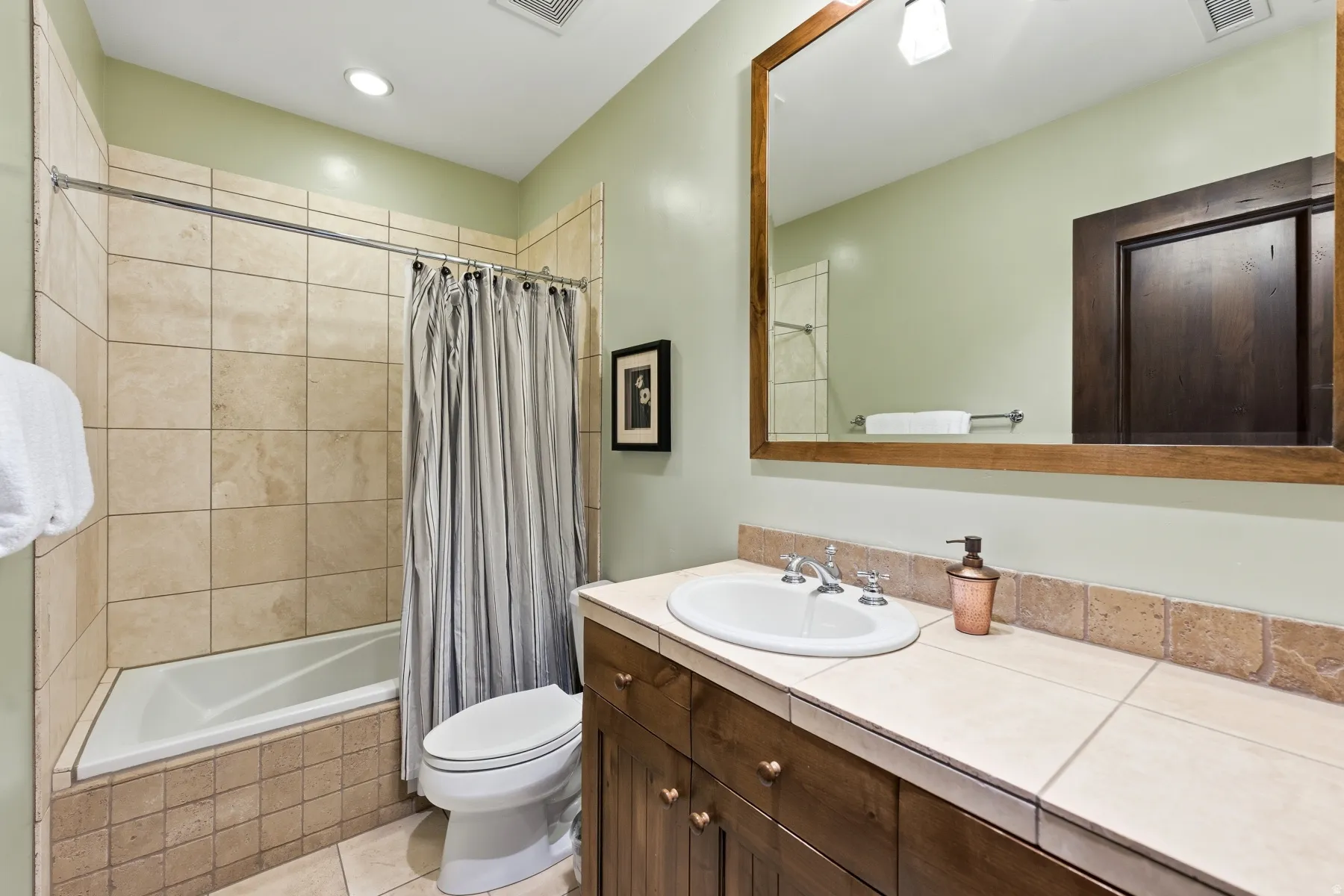 Bathroom with tiled shower / bath, vanity, recessed lighting, and light tile patterned flooring