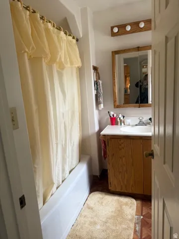 Bathroom with vanity and shower / tub combo