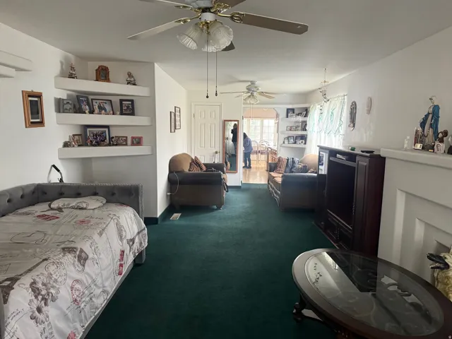Bedroom featuring dark carpet and a ceiling fan
