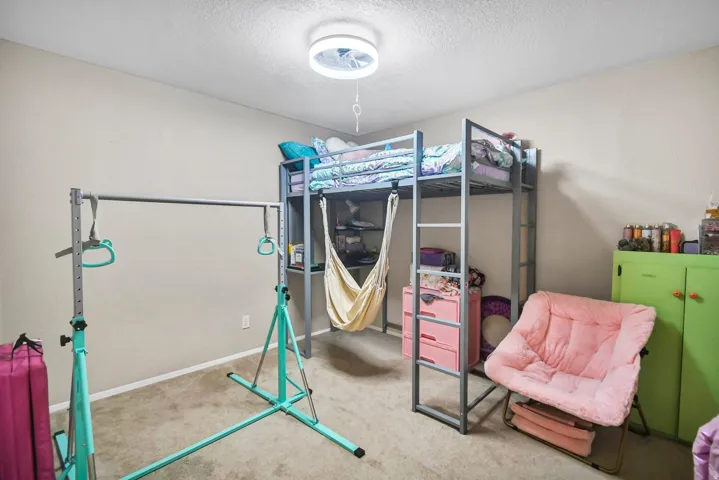 Bedroom with a textured ceiling and carpet flooring