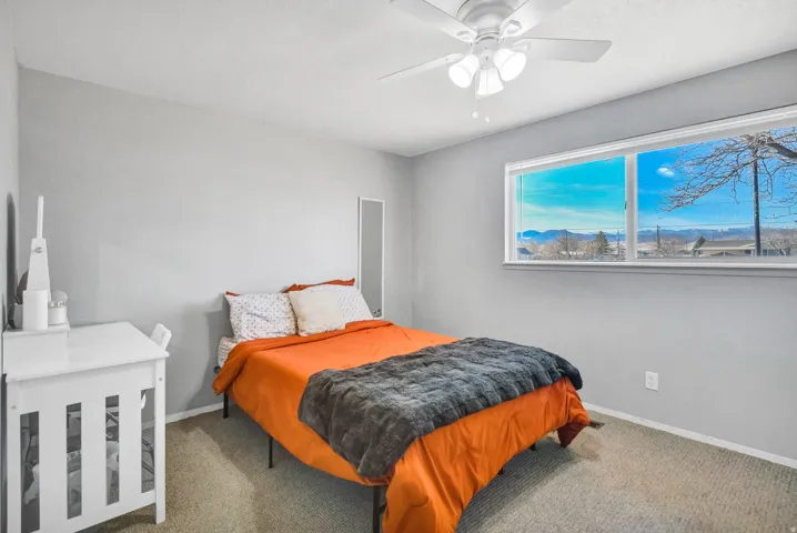 Bedroom featuring carpet flooring, a ceiling fan, and a mountain view