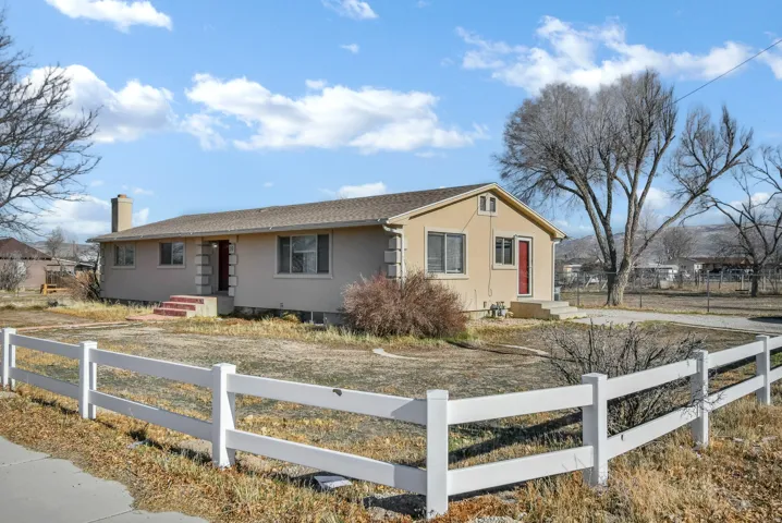 Single story home featuring a fenced front yard, stucco siding, and a chimney