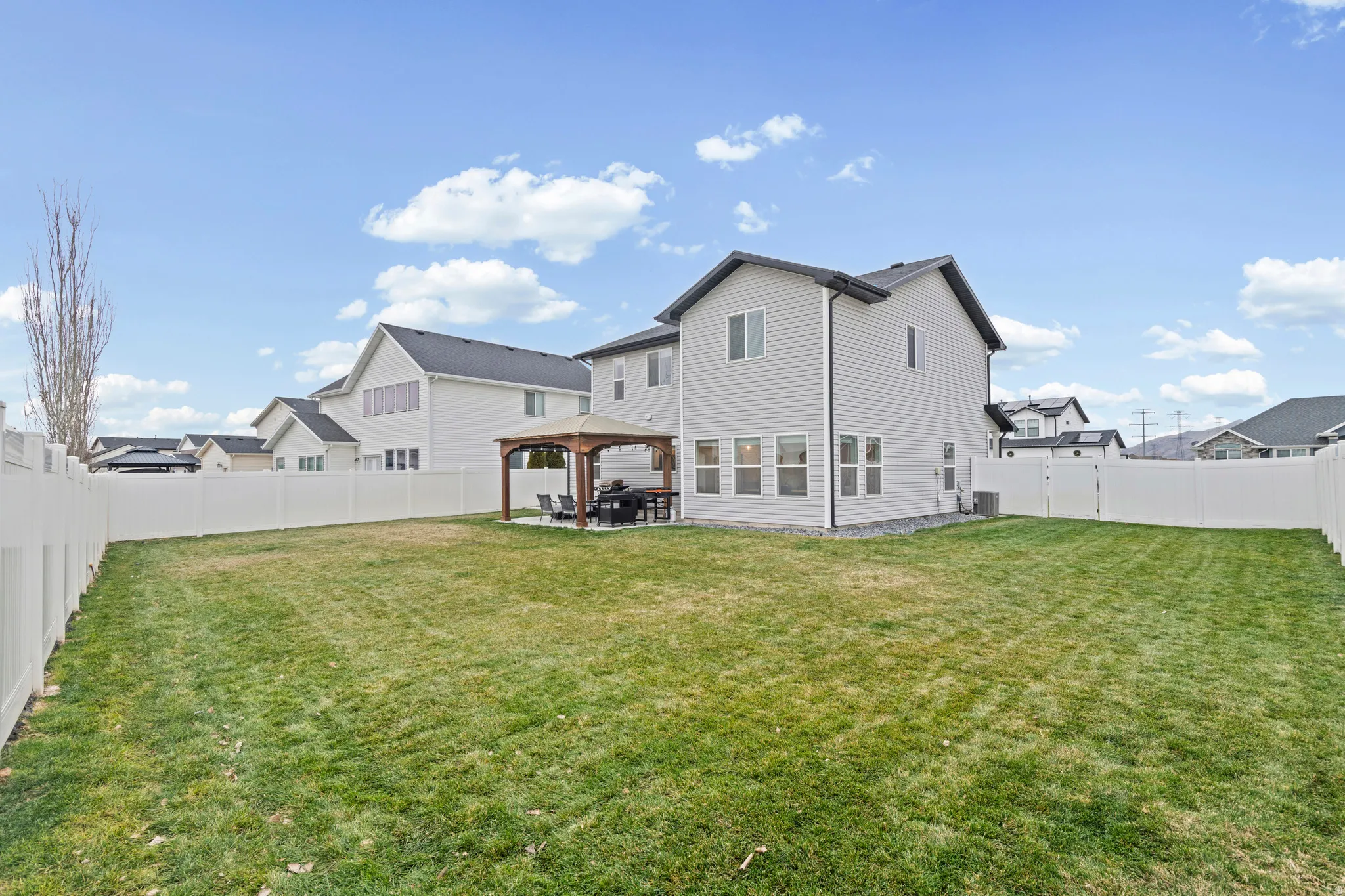 Back of house with a gazebo, a patio, and a fenced backyard
