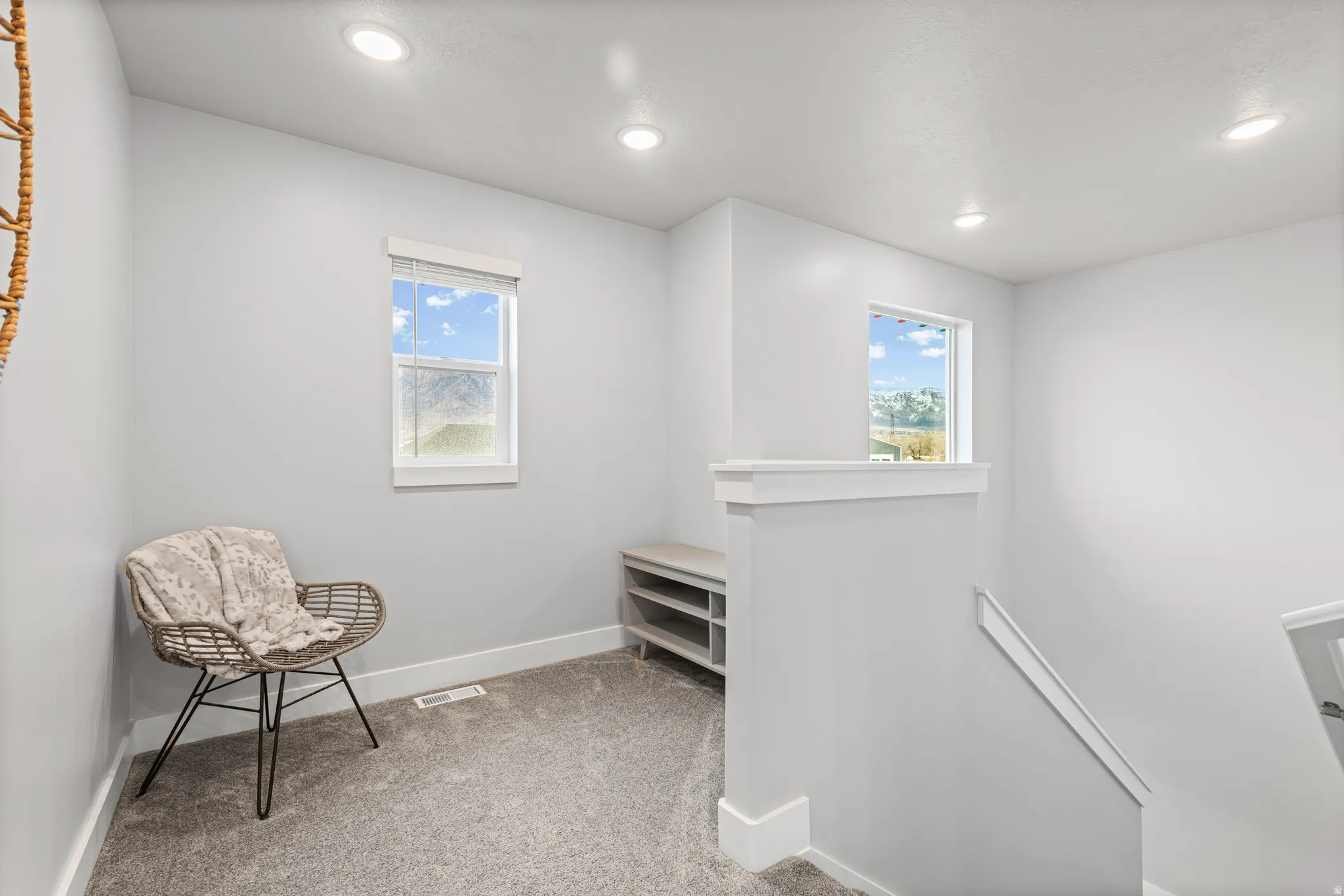 Living area with an upstairs landing, light carpet, and recessed lighting