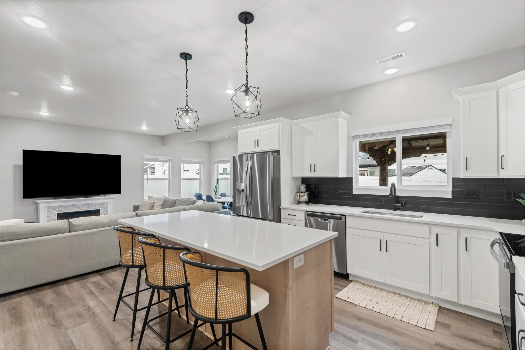 Kitchen with a breakfast bar, white cabinets, a kitchen island, pendant lighting, and recessed lighting