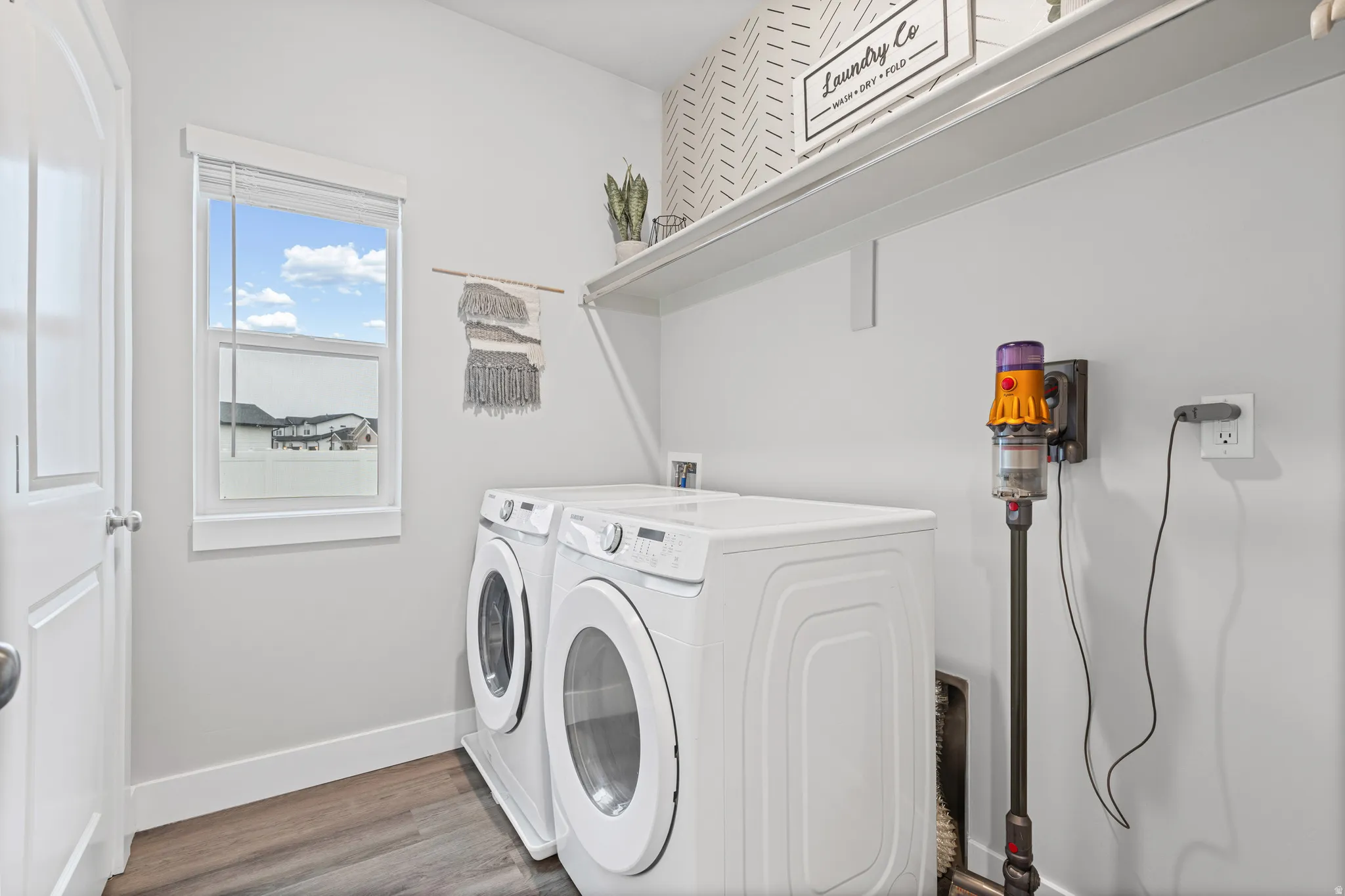 Laundry room with wood finished floors and washer and dryer