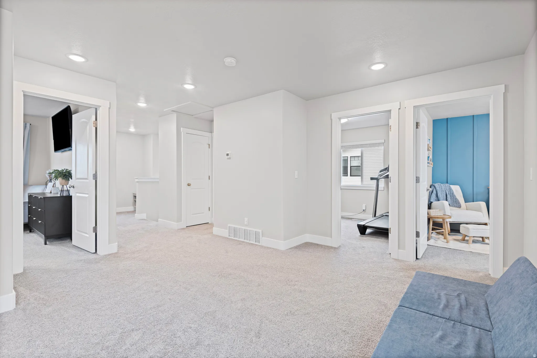 Living area featuring light colored carpet, recessed lighting, and attic access