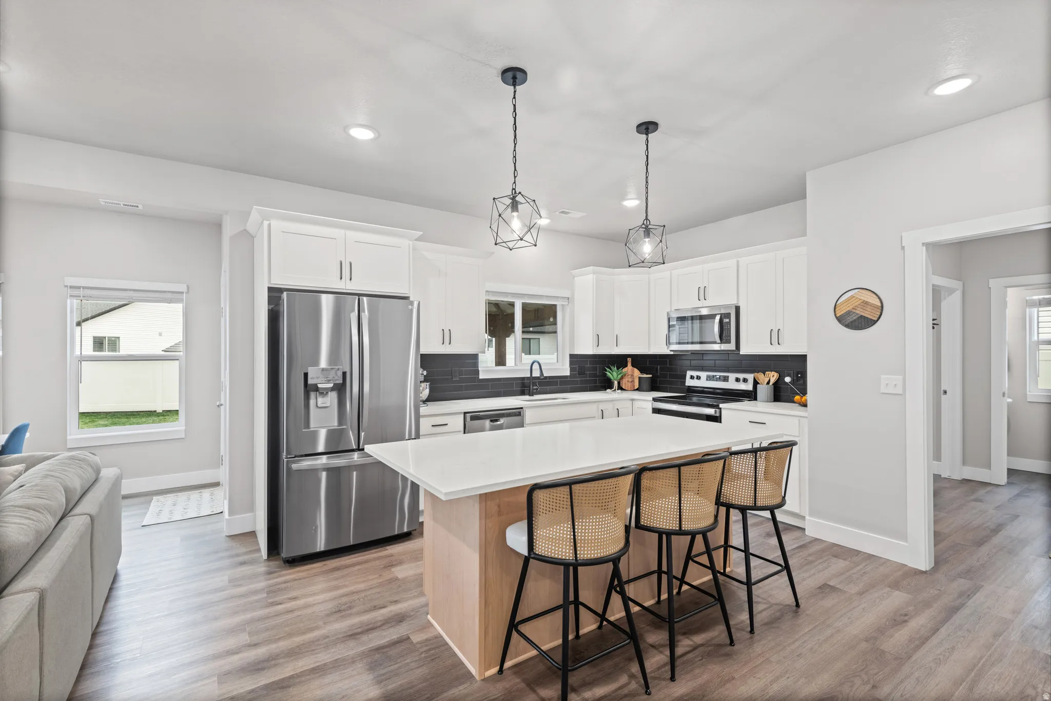 Kitchen with healthy amount of natural light, a kitchen breakfast bar, stainless steel appliances, and recessed lighting