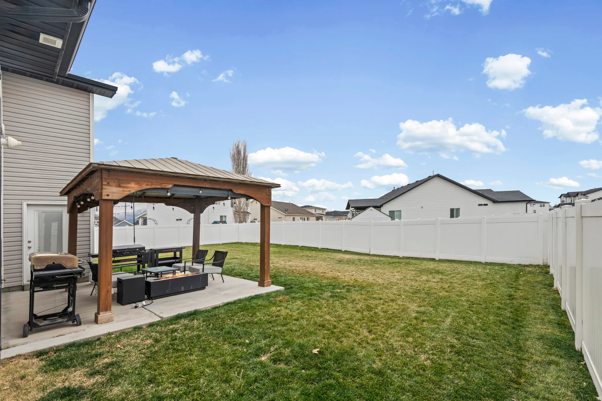 Fenced backyard with a gazebo, a patio, and an outdoor living space