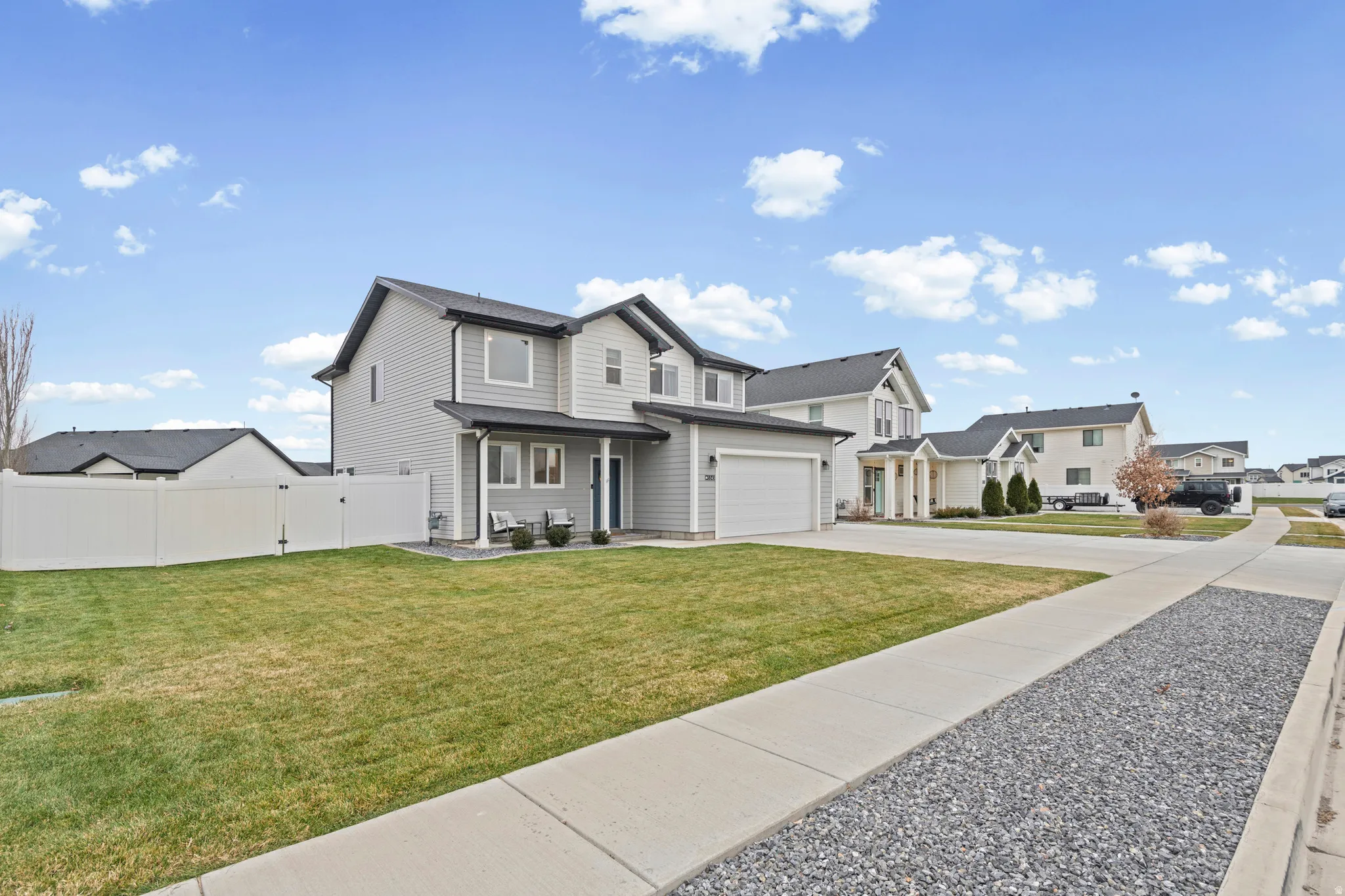 View of front of house with driveway, a residential view, covered porch, and a garage