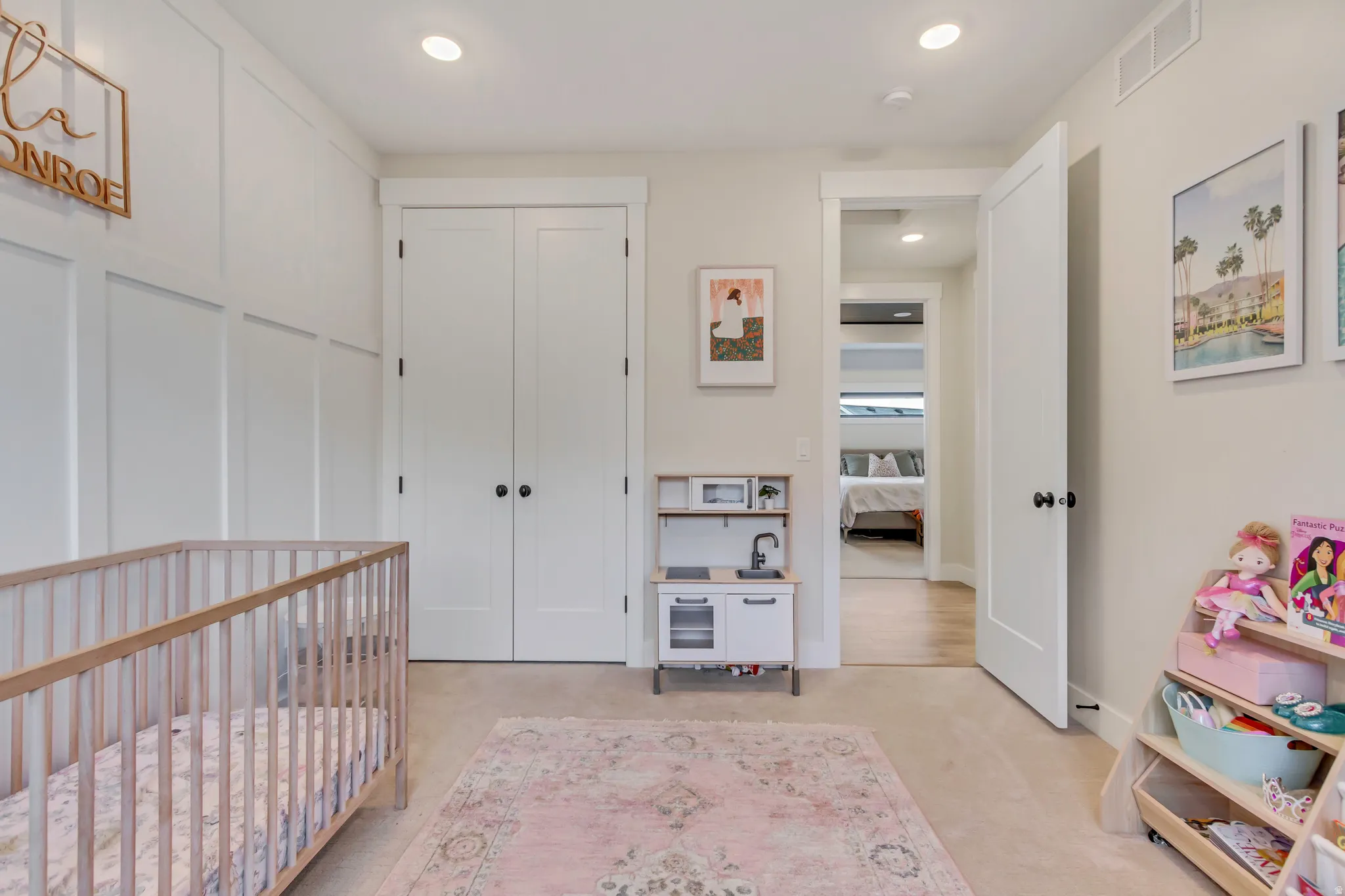 Bedroom featuring a nursery area, light colored carpet, recessed lighting, and a closet