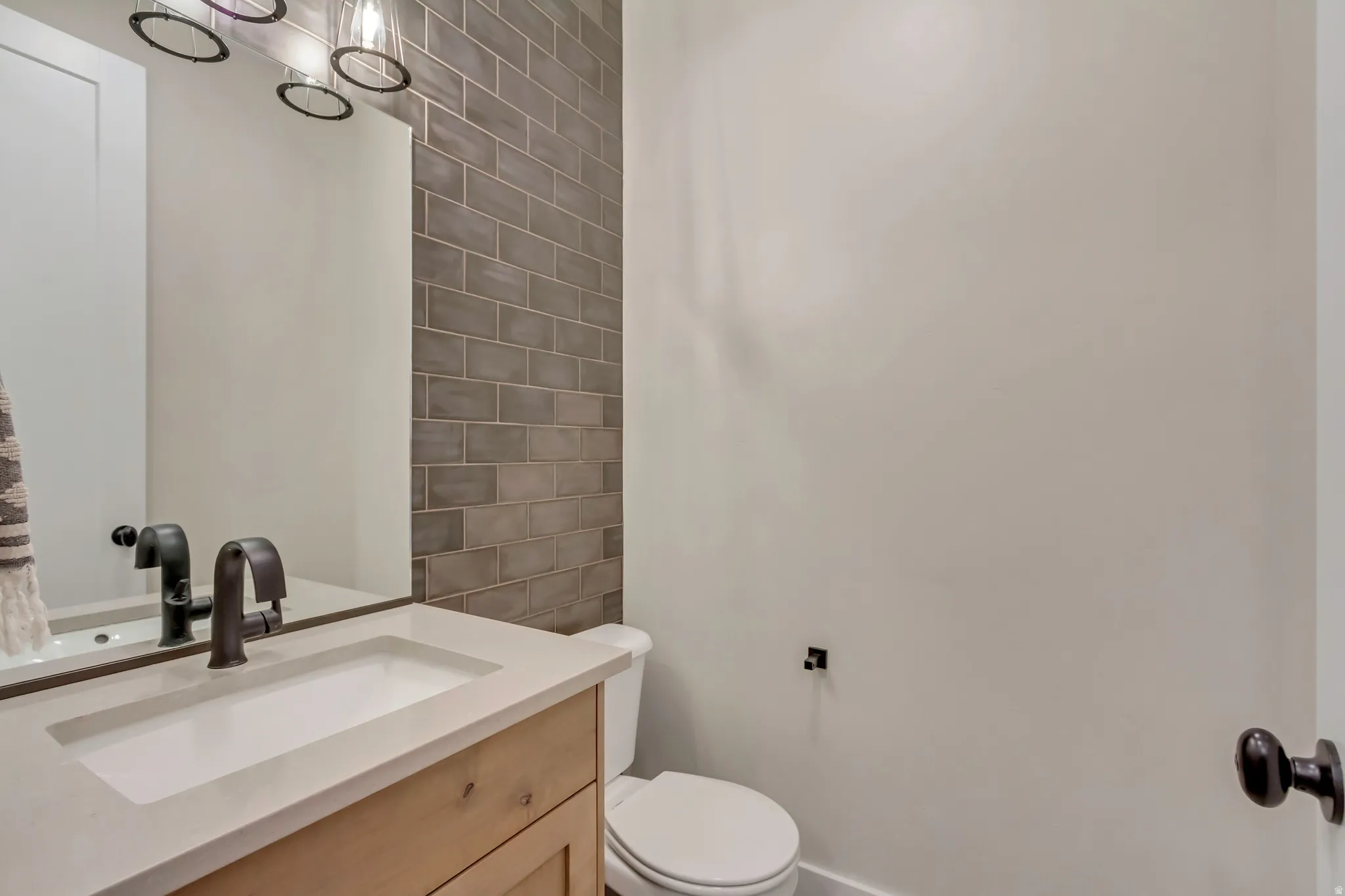 Half bath featuring vanity and tile walls