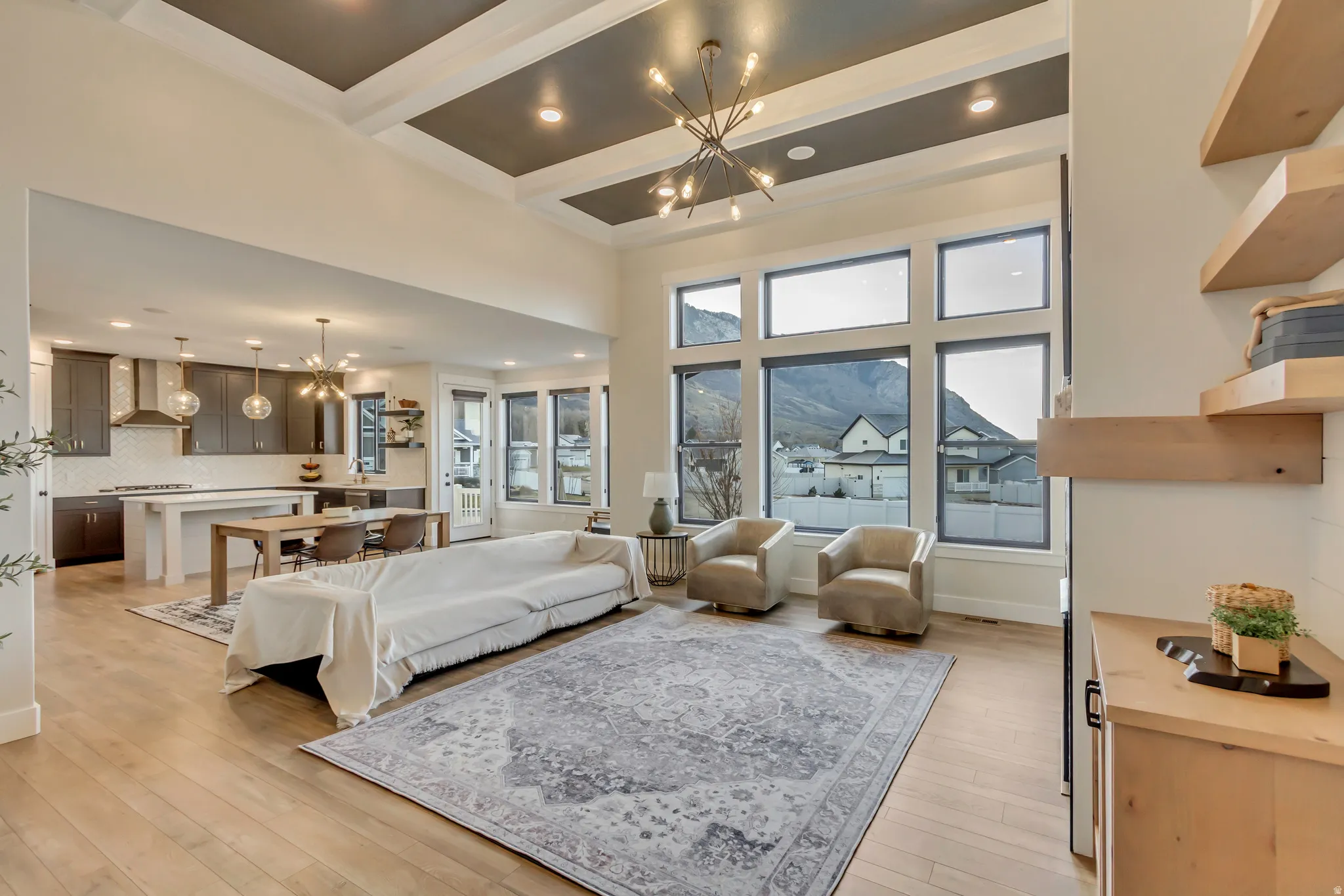 Living room with a chandelier, light wood-style flooring, beamed ceiling, coffered ceiling, and recessed lighting