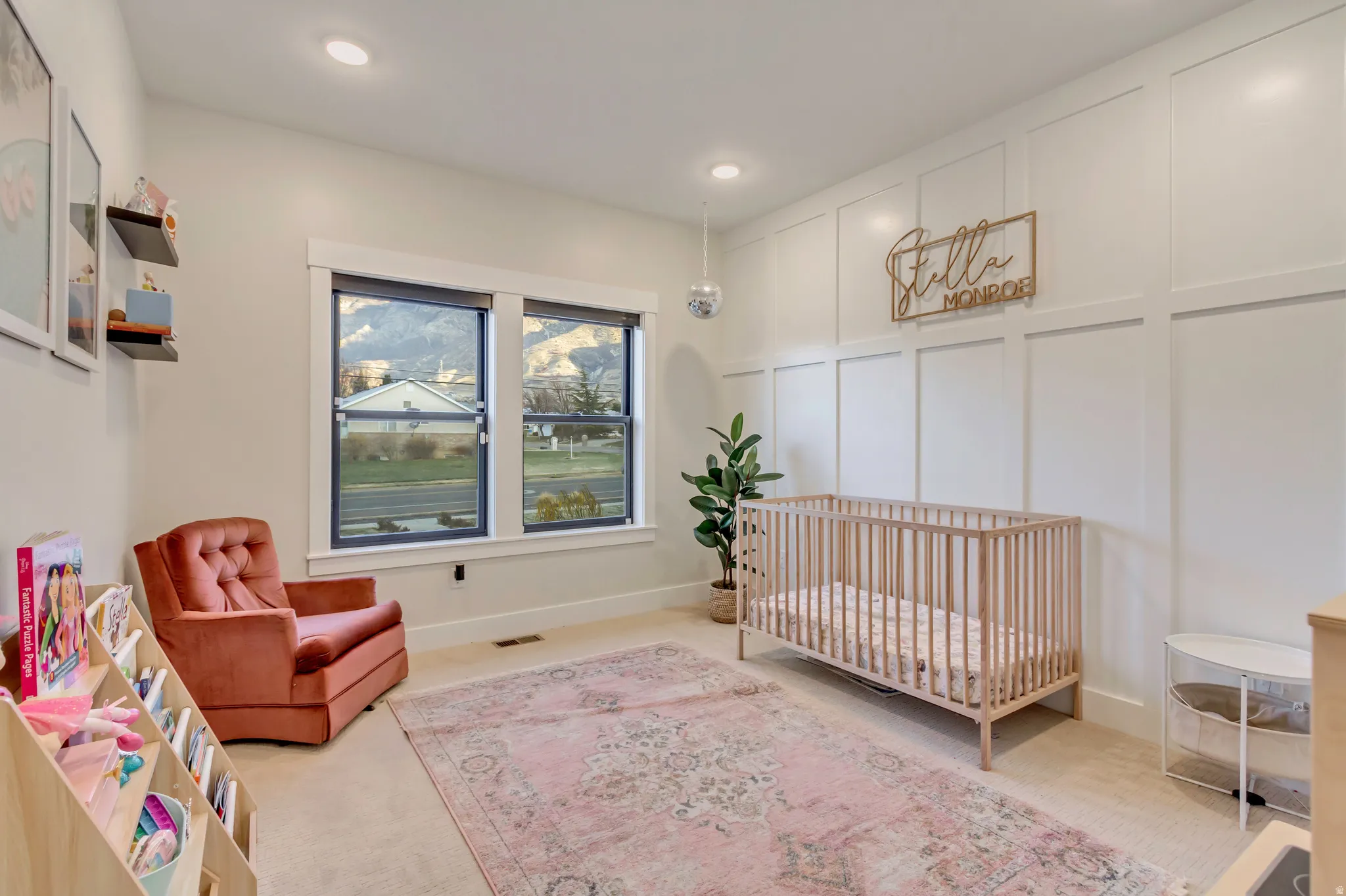 Bedroom with a decorative wall, a nursery area, carpet floors, and recessed lighting