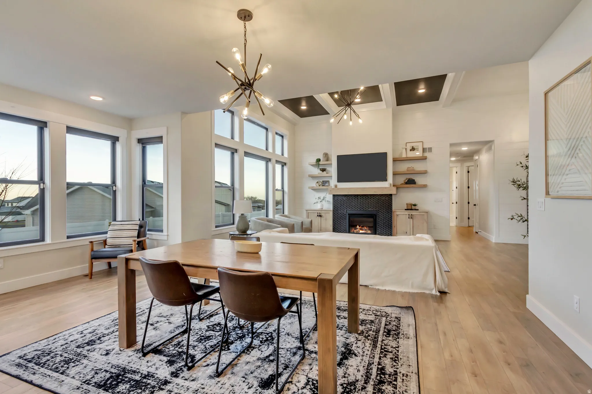 Dining room with a tile fireplace, healthy amount of natural light, light wood finished floors, beamed ceiling, and recessed lighting