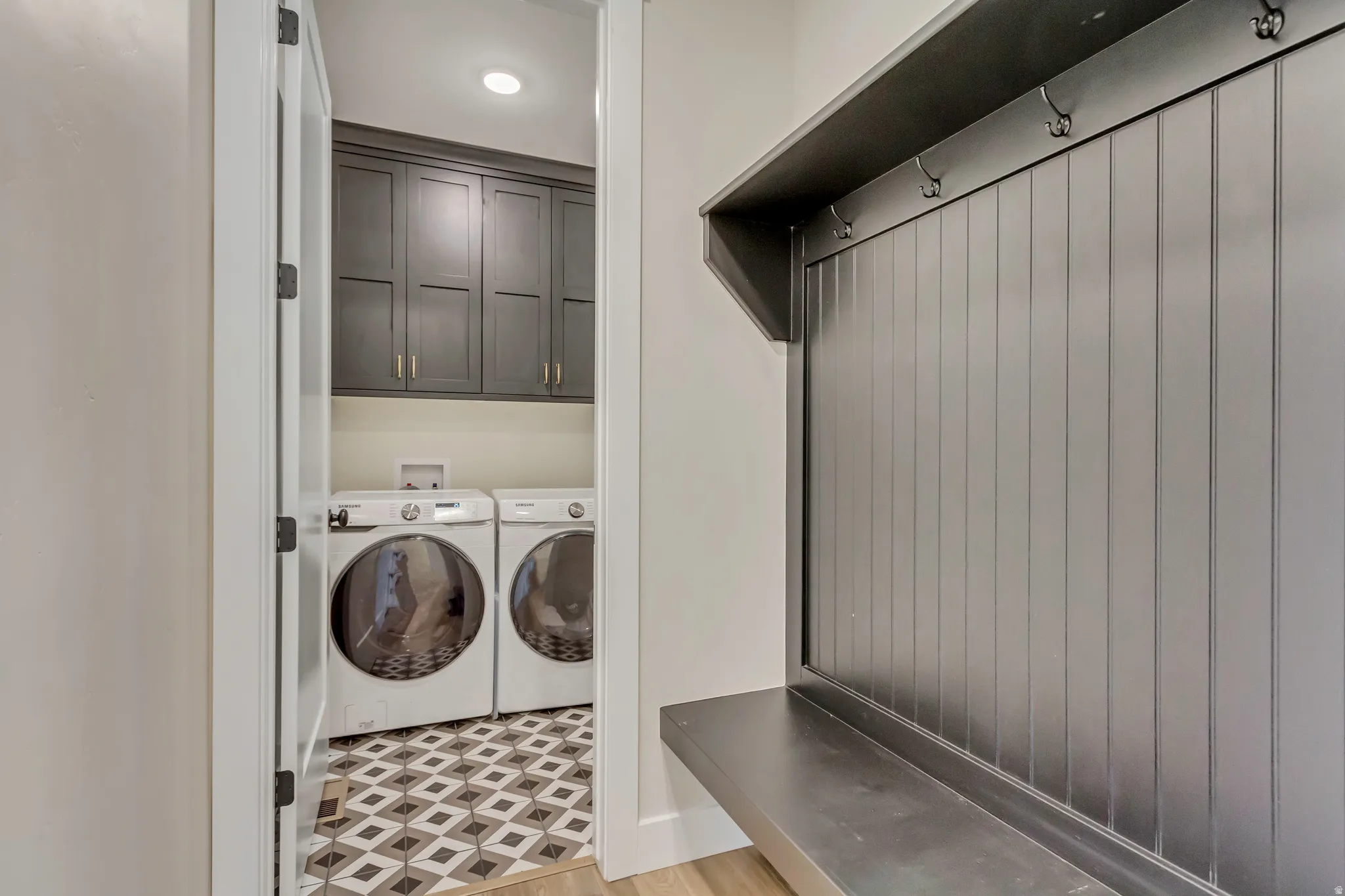 Laundry area featuring independent washer and dryer and cabinet space