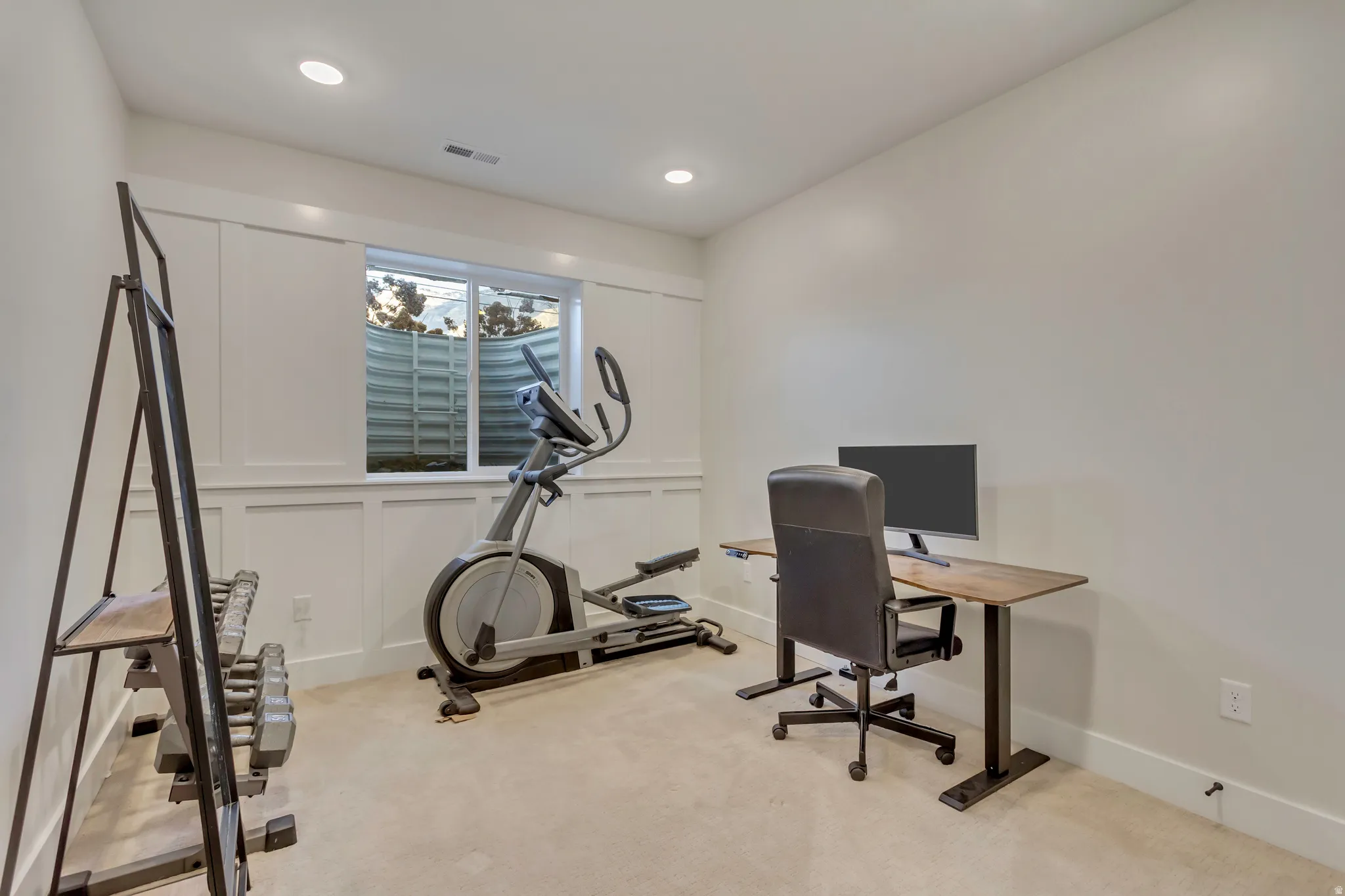 Office area featuring a decorative wall and light carpet