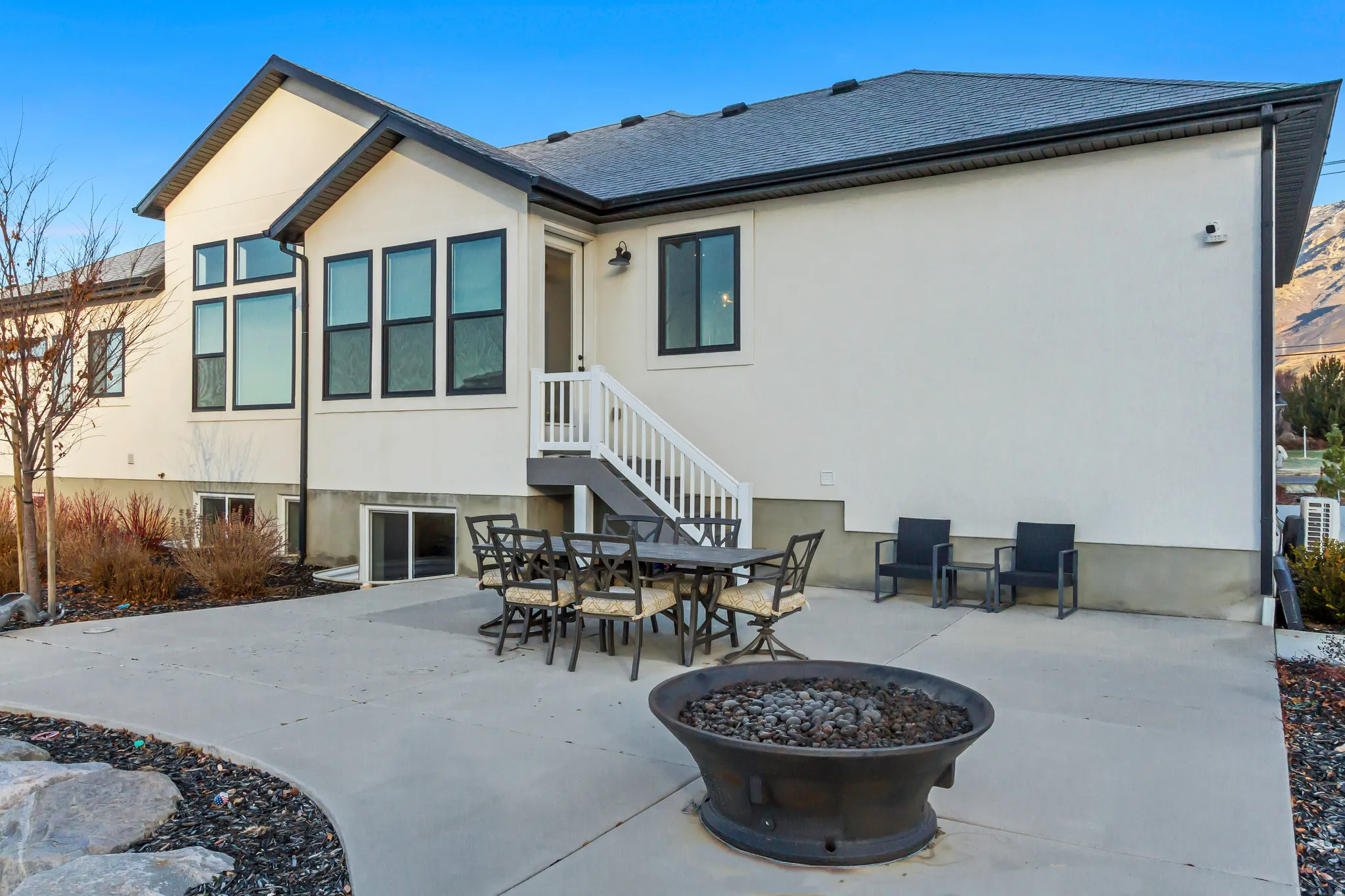 Back of house with a patio, a fire pit, stucco siding, and roof with shingles