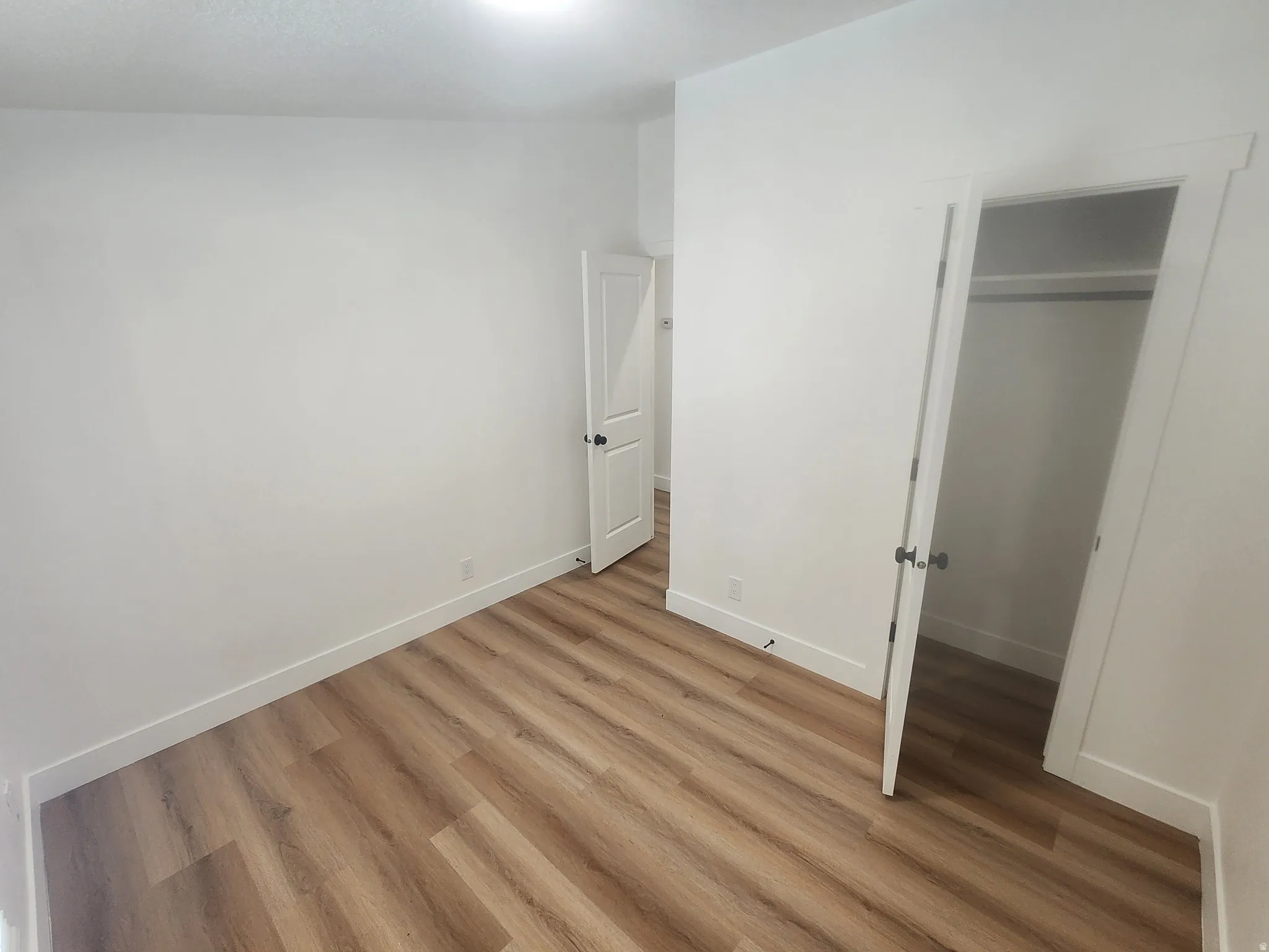Unfurnished bedroom with a closet and wood finished floors
